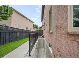 A brick building with a black fence in front.