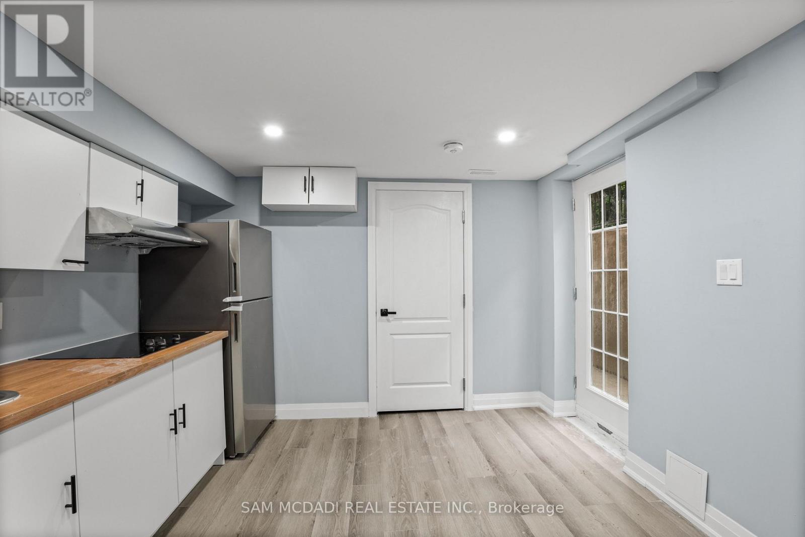 A kitchen with a white door and cabinets.