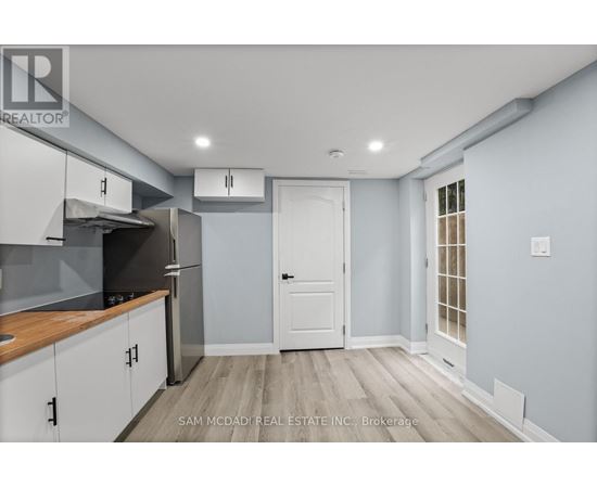 A kitchen with a white door and cabinets.