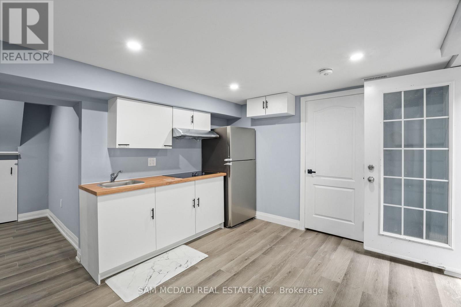 A kitchen with white cabinets and a wooden countertop.