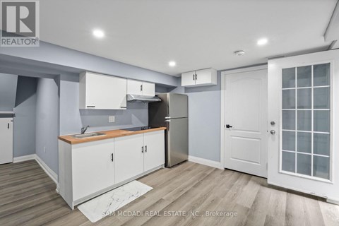 A kitchen with white cabinets and a wooden countertop.