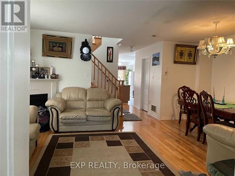 A living room with a tan couch and a brown rug.