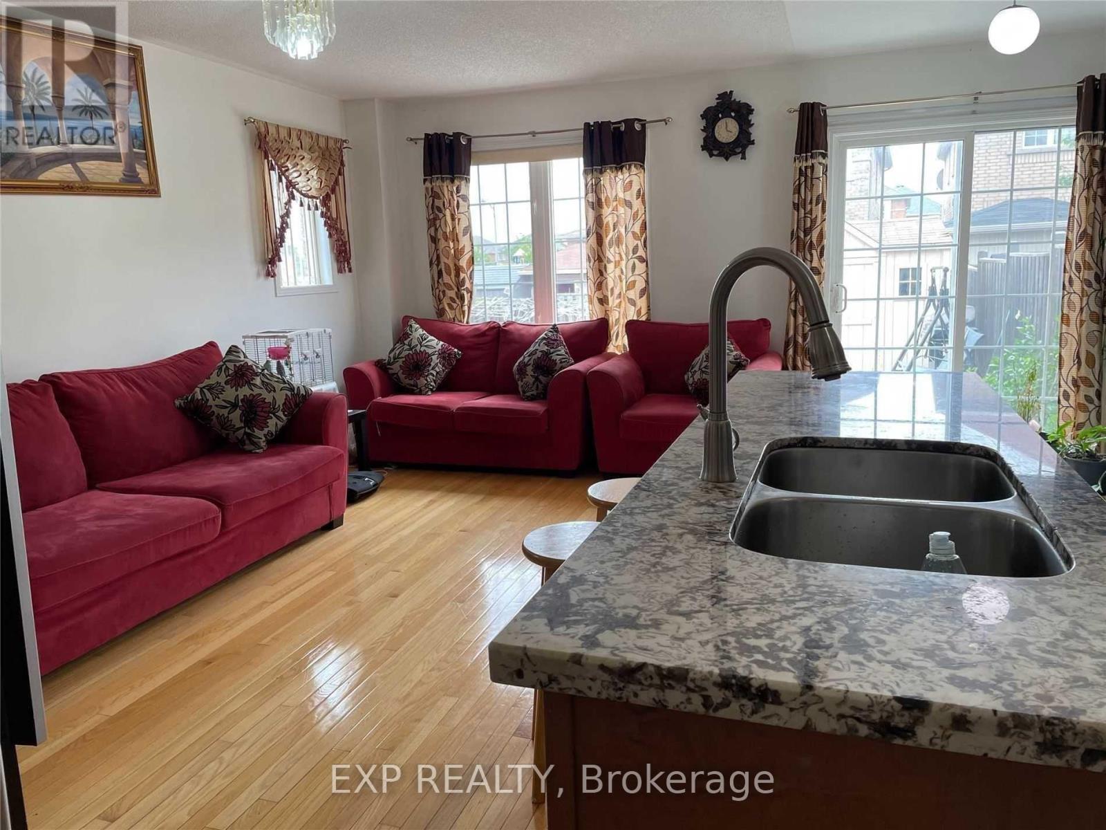 A kitchen with a marble countertop and red couches.