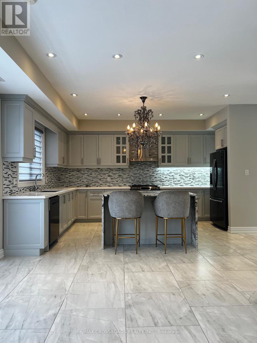 A modern kitchen with a marble backsplash and a chandelier.