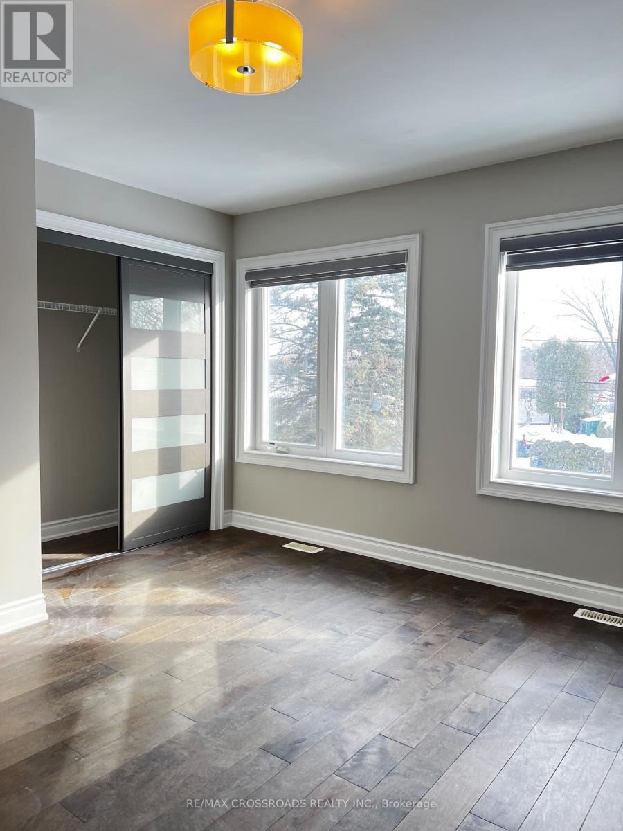 A room with a grey floor and a window with a view of trees.