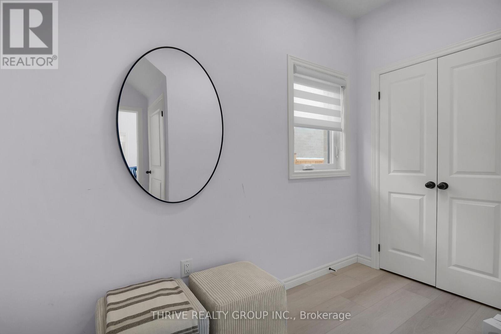A bedroom with a round mirror on the wall.