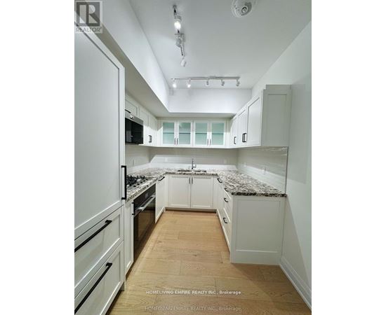 A kitchen with white cabinets and a granite countertop.