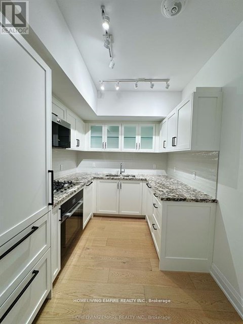 A kitchen with white cabinets and a granite countertop.