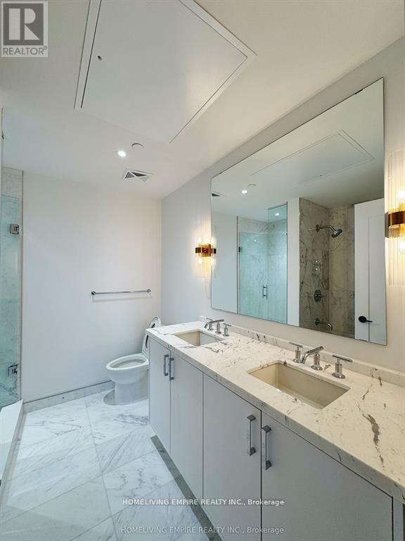 A bathroom with a sink, mirror, and toilet.