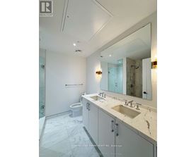 A bathroom with a sink, mirror, and toilet.