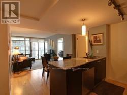 A kitchen with a bar and chairs in the middle of the room.