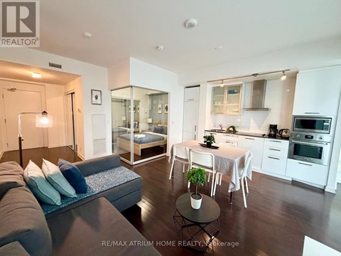 A modern living room with a grey couch and a glass wall.
