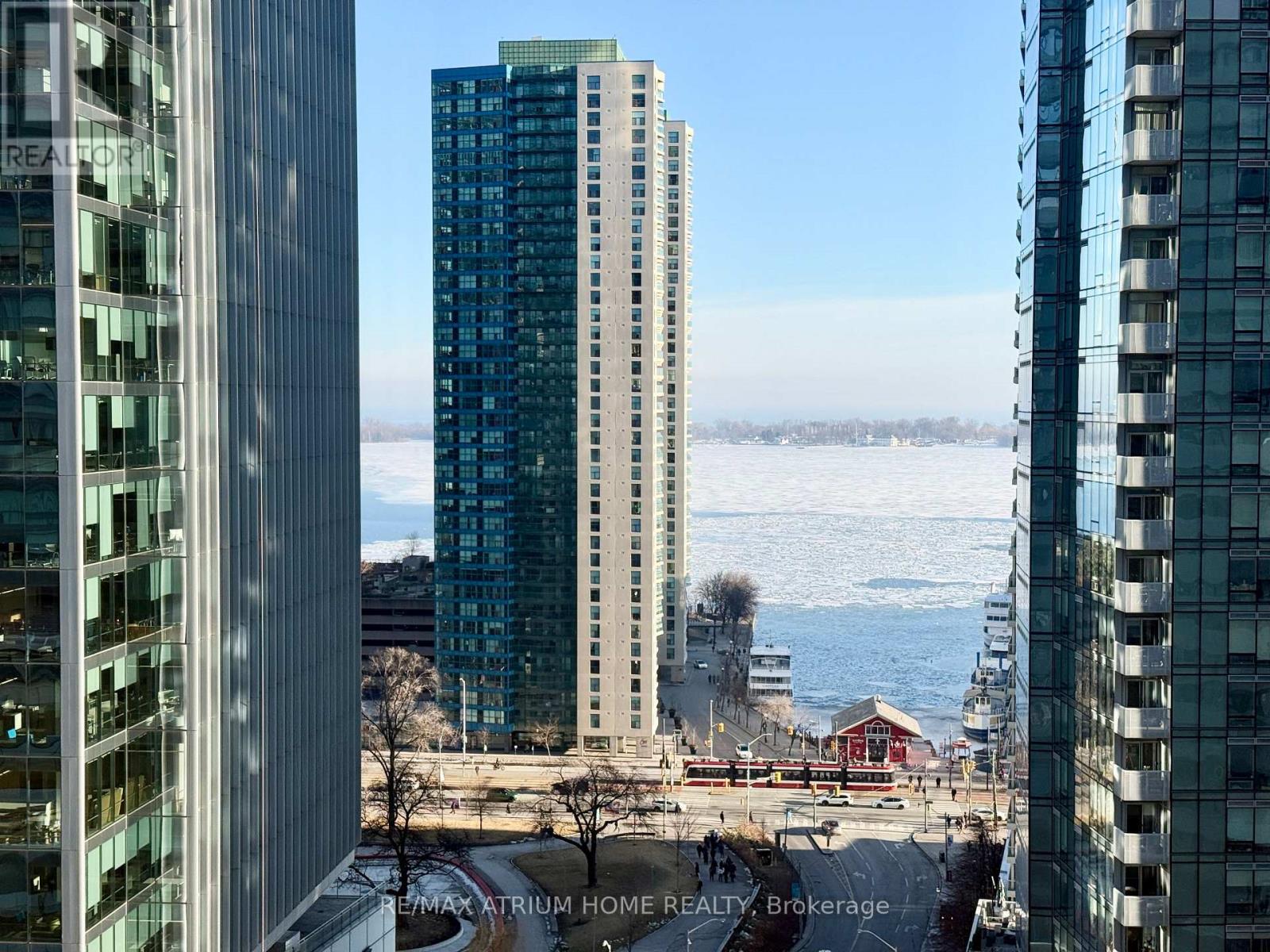 A view of a cityscape with buildings and a body of water in the distance.