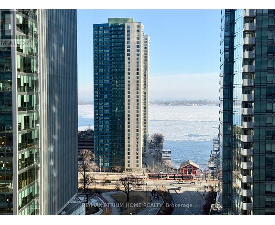 A view of a cityscape with buildings and a body of water in the distance.