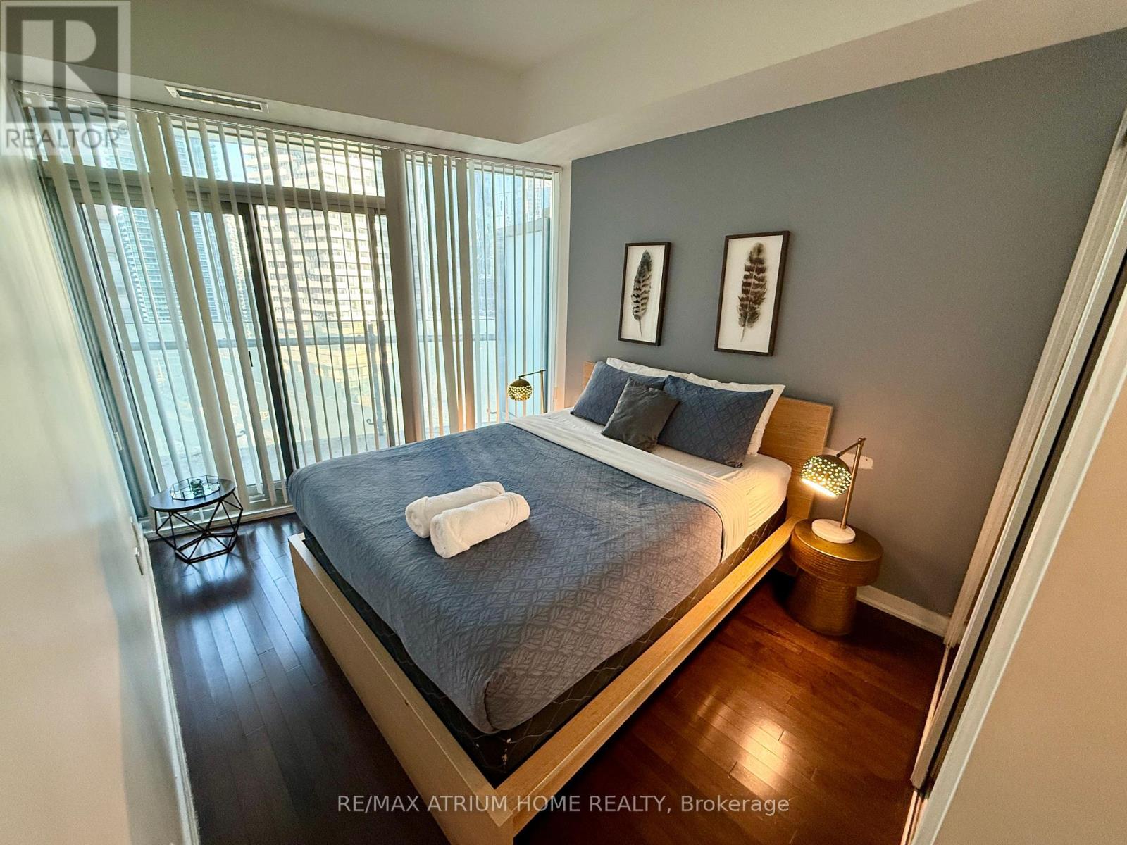 A bedroom with a bed, nightstand, and window.