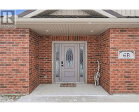 A house with a grey door and a sign that says 6B.