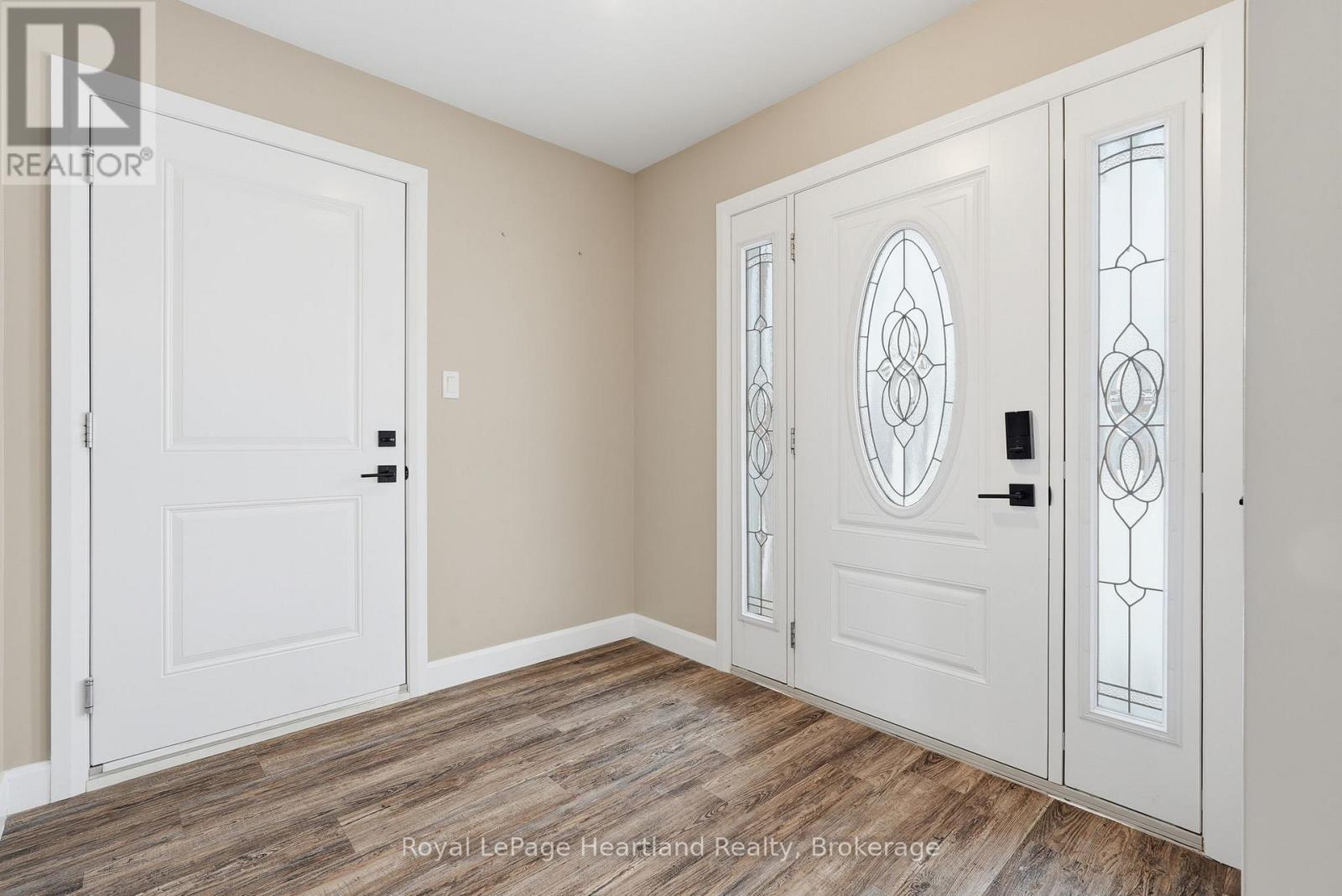 A room with a white door and a white door with a glass panel and stained glass window.