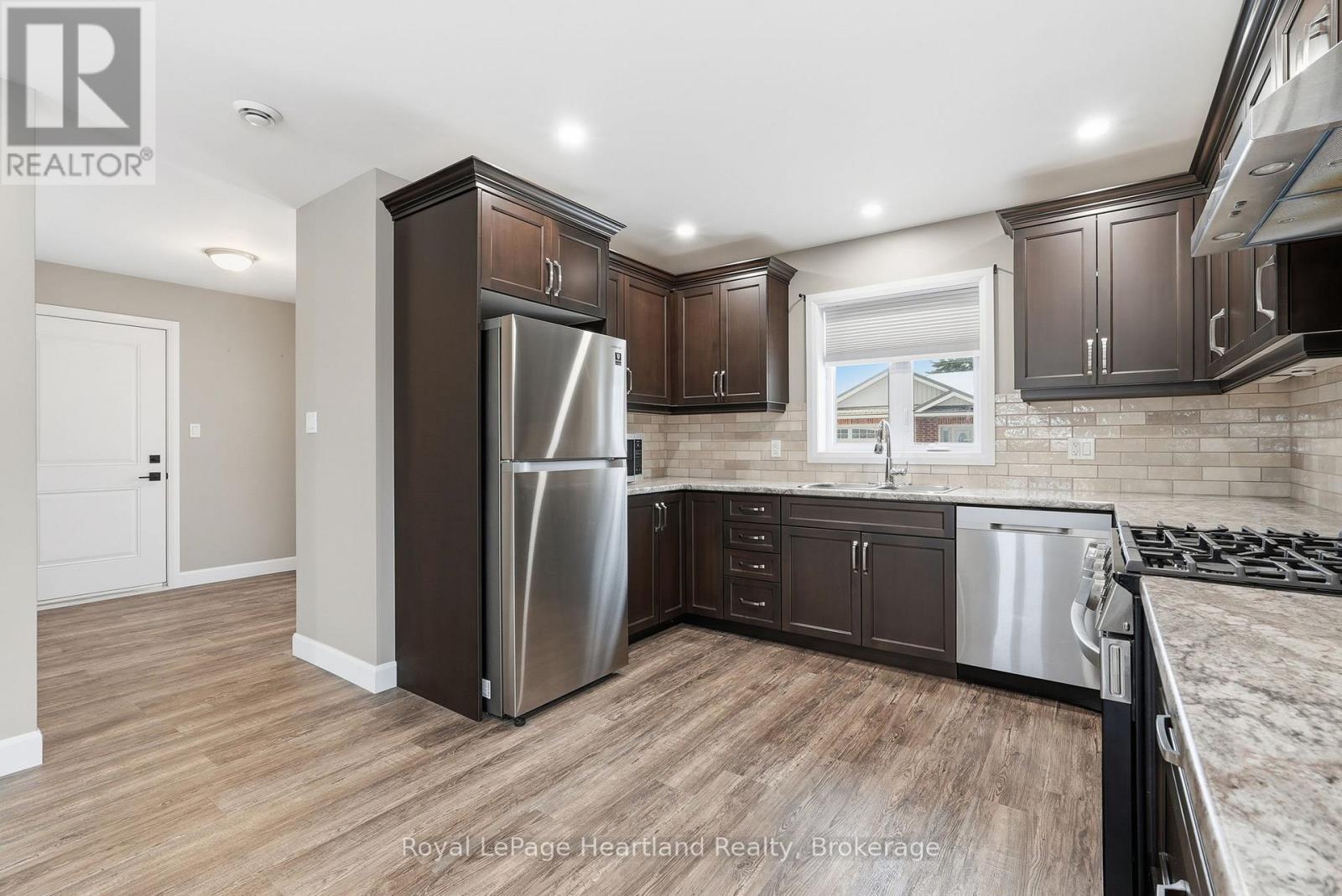 A kitchen with dark wood cabinets and stainless steel appliances.