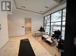 A realtor is showing a spacious living room with a large window.