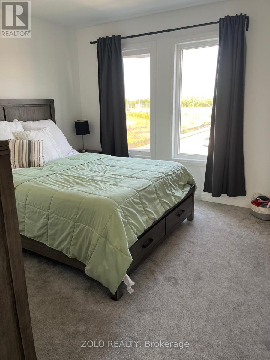 A bedroom with a bed, nightstand, and window.