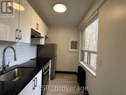 A kitchen with black countertops and white cabinets.