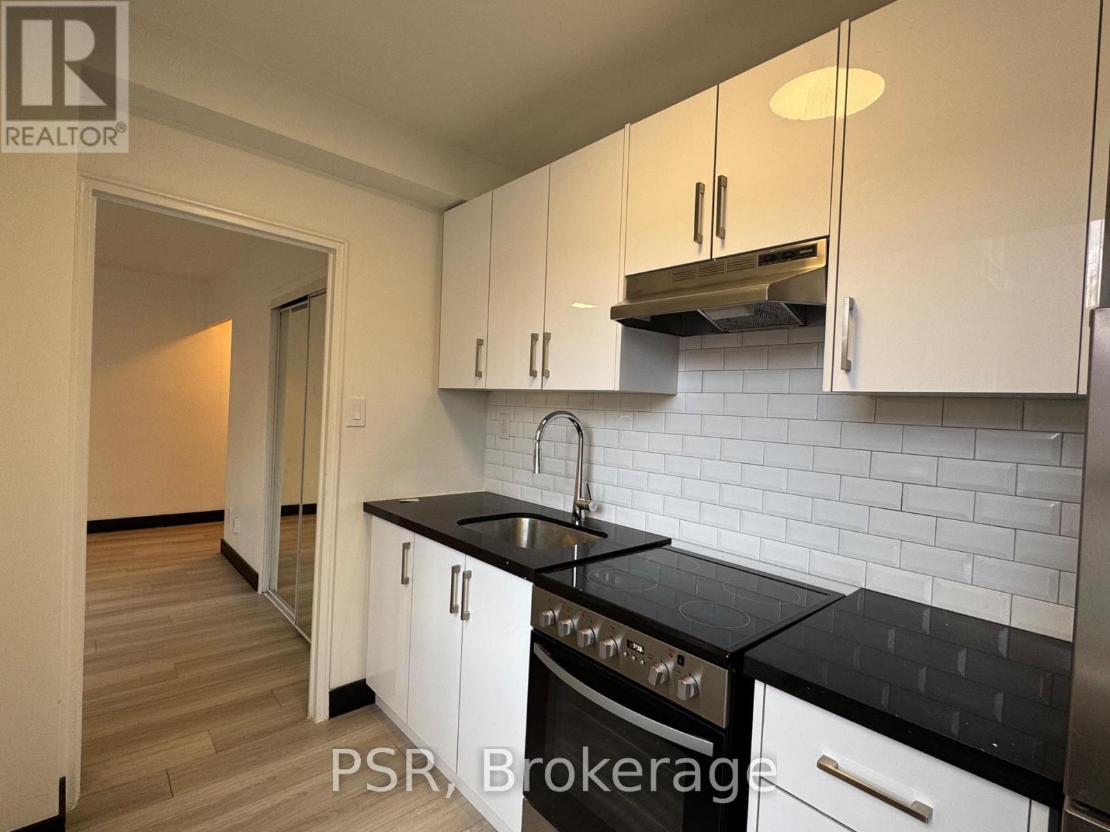 A kitchen with black countertops and white cabinets.