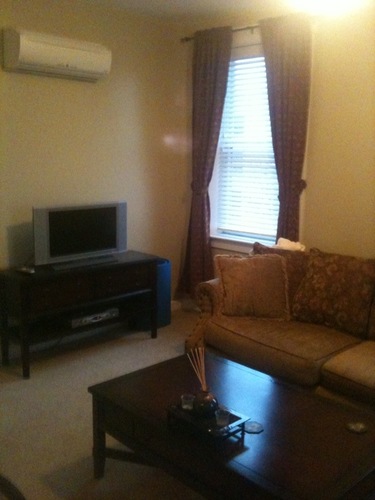 A living room with a couch, a television, and a coffee table.