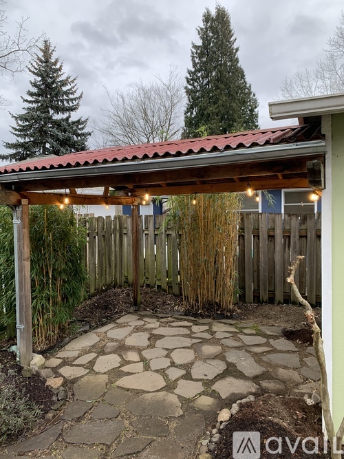 A patio with a stone walkway and a wooden fence.