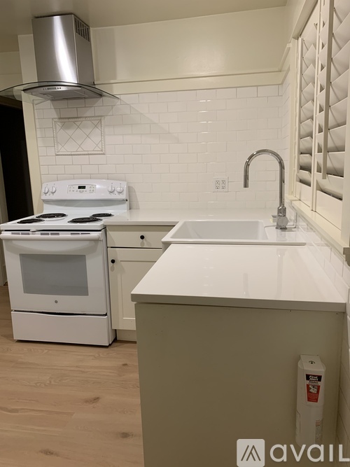 A white stove and oven in a kitchen with a white tile backsplash.