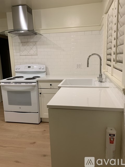 A white stove and oven in a kitchen with a white tile backsplash.