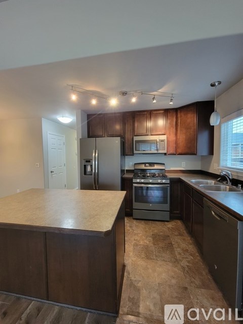 A kitchen with brown cabinets and a granite countertop.