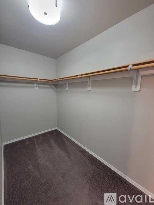A room with a carpeted floor and a long white pipe on the wall.