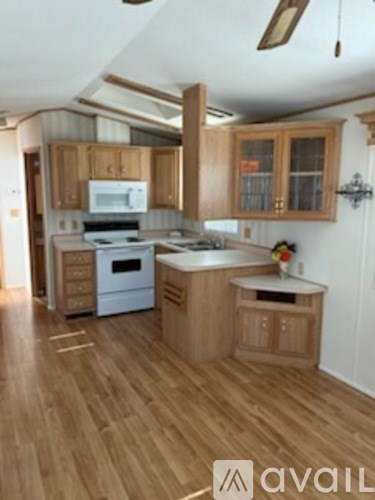 A kitchen with wooden floors and cabinets.