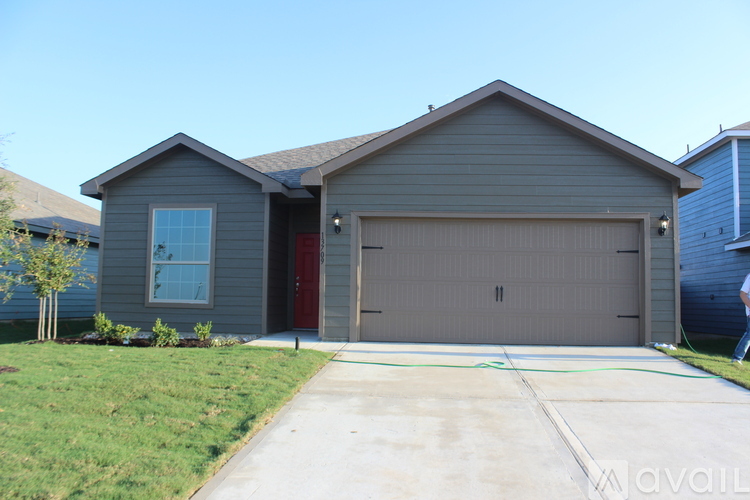 A house with a garage door and a driveway in front.