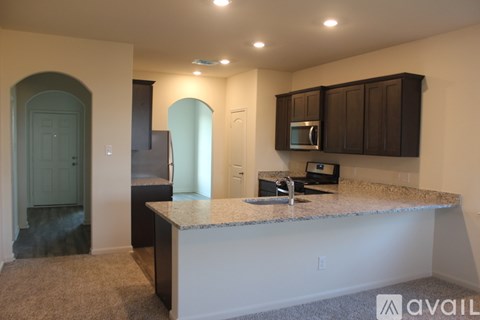 A kitchen with a granite countertop and a microwave above it.
