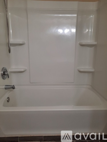 A white bathtub with a silver faucet and a silver handle.