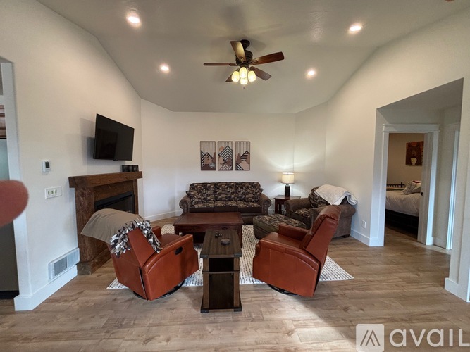 A living room with a fireplace and a television on the wall.