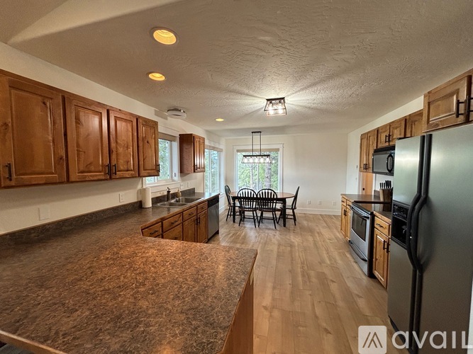 A kitchen with wooden cabinets and a black refrigerator.
