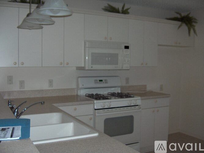 A kitchen with white cabinets and a white stove.