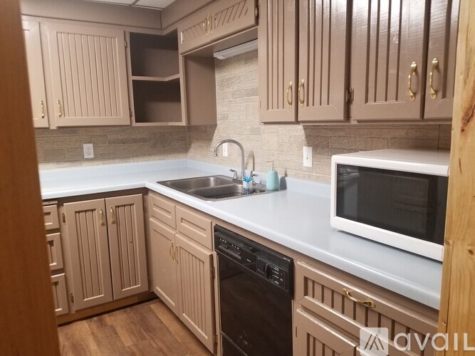 A kitchen with brown cabinets and a white countertop.