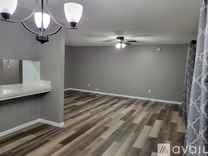 A room with wooden flooring and a ceiling fan.