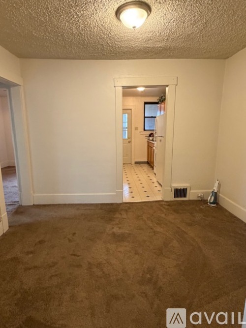 A room with a carpeted floor and a doorway leading to another room.