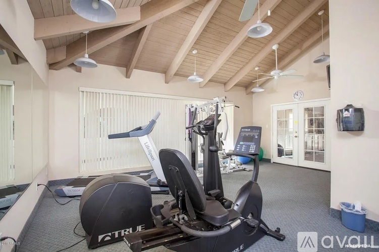 A home gym with a stationary bike and a rowing machine.