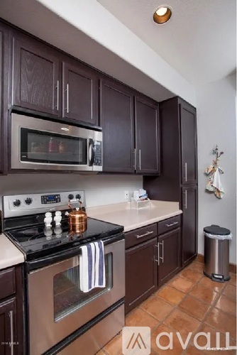 A kitchen with brown cabinets and a black stove top.