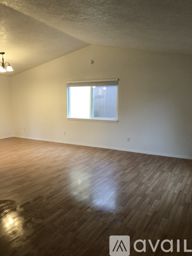 A room with wooden flooring and a window.