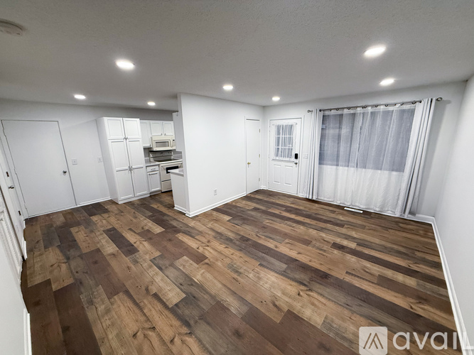 A room with wooden flooring and white walls.