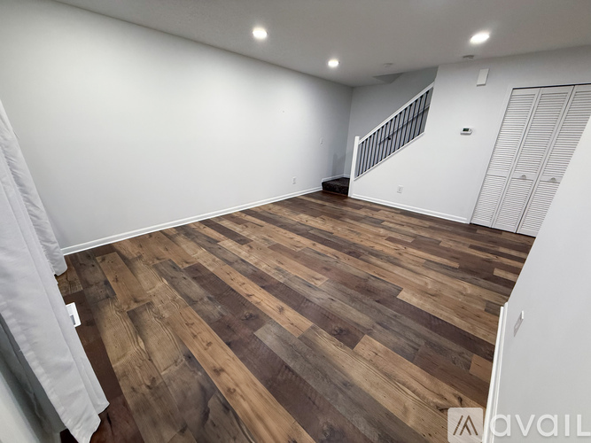 A room with wooden flooring and a staircase.
