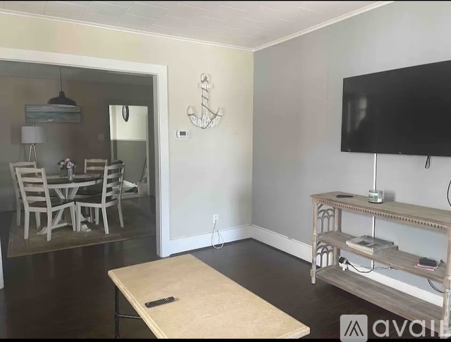 A room with a table, chairs, and a television.