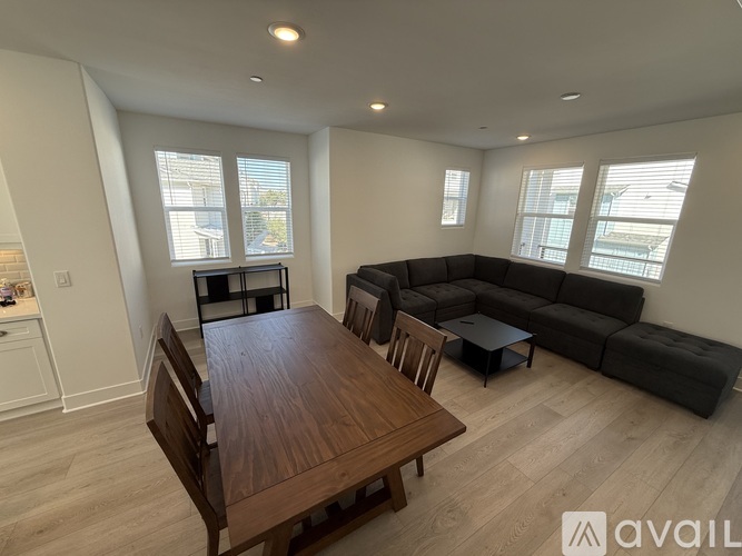 A living room with a wooden table and a black couch.