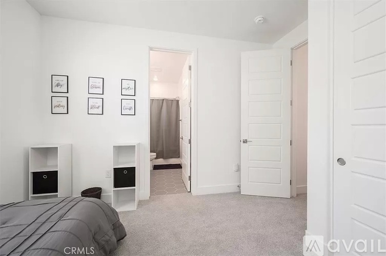 A bedroom with a bed, nightstands, and pictures on the wall.